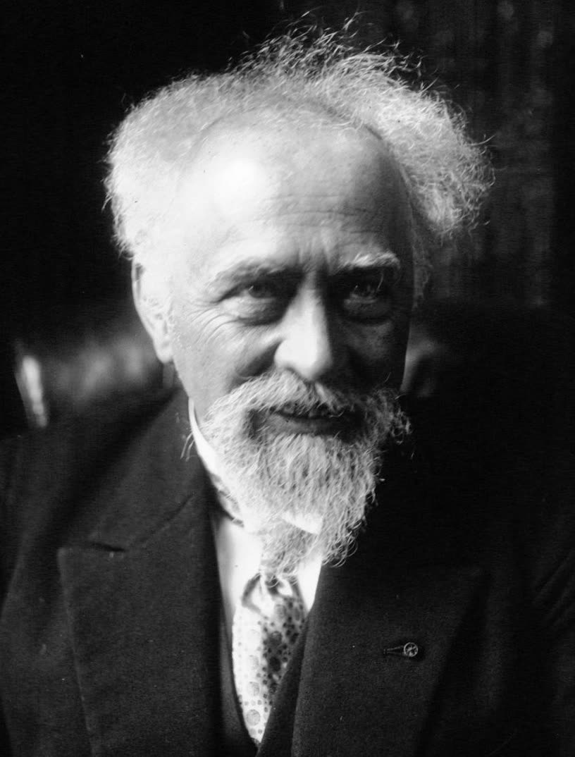 A photograph of Jean Perrin in middle age, in a suit and tie, facing the camera.