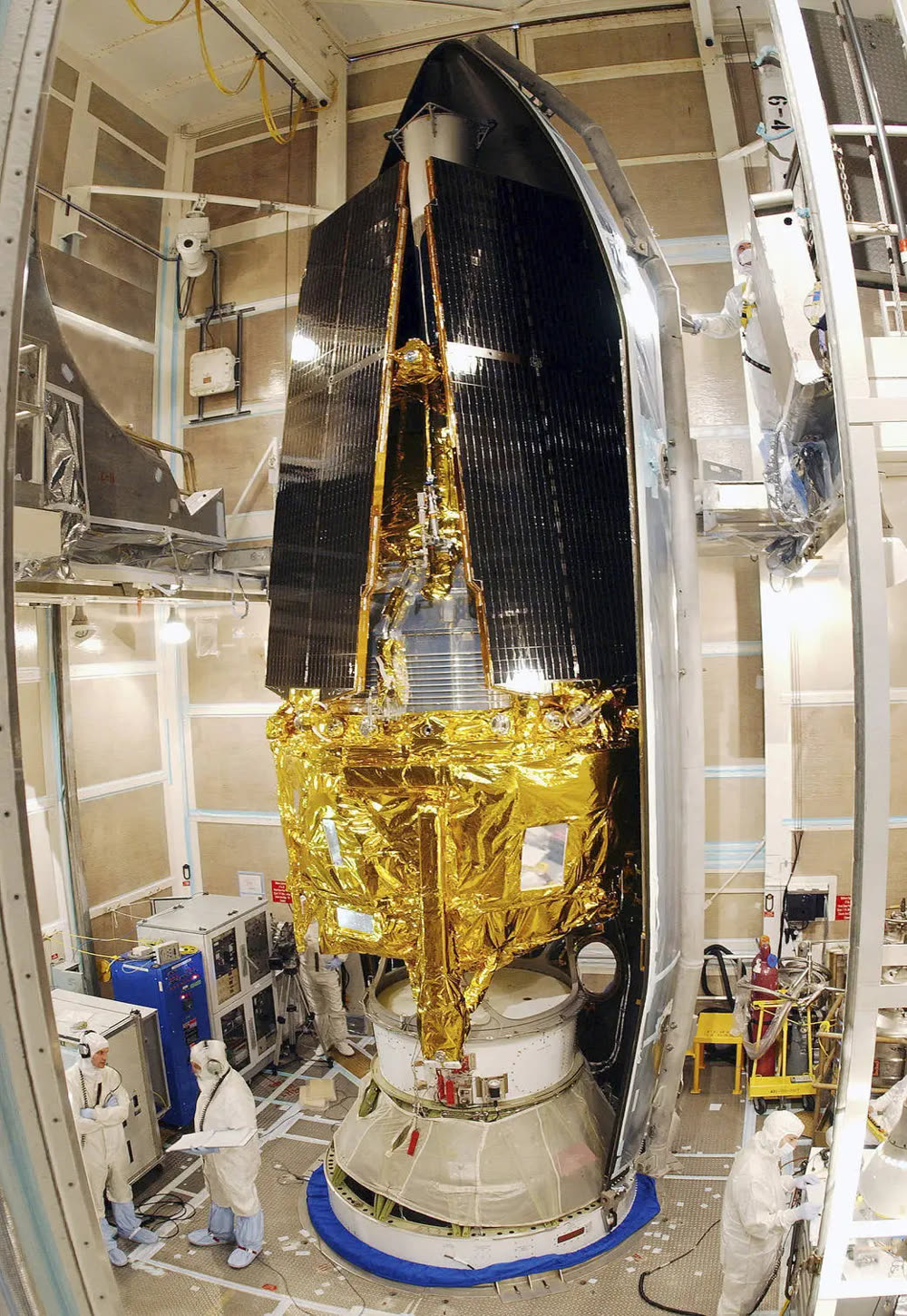 The Gravity Probe B spacecraft in a clean room before launch, technicians alongside for scale.