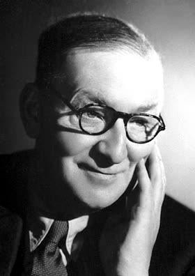 Portrait photograph of John Cockcroft in a suit.