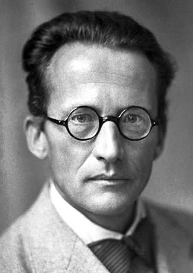A black and white portrait photograph of Erwin Schrödinger in 1933, in a suit and round spectacles, facing the camera.