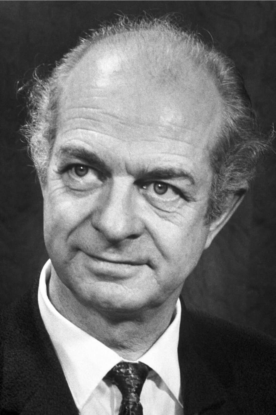 A black and white photograph of Linus Pauling in 1962, in a suit and tie, looking slightly to the side.