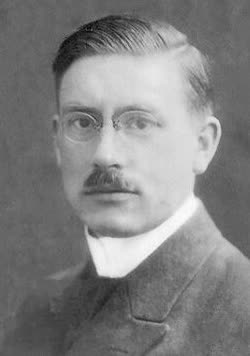 A black and white photographic portrait of Peter Debye as a young man in a high collar and tie, facing slightly left.